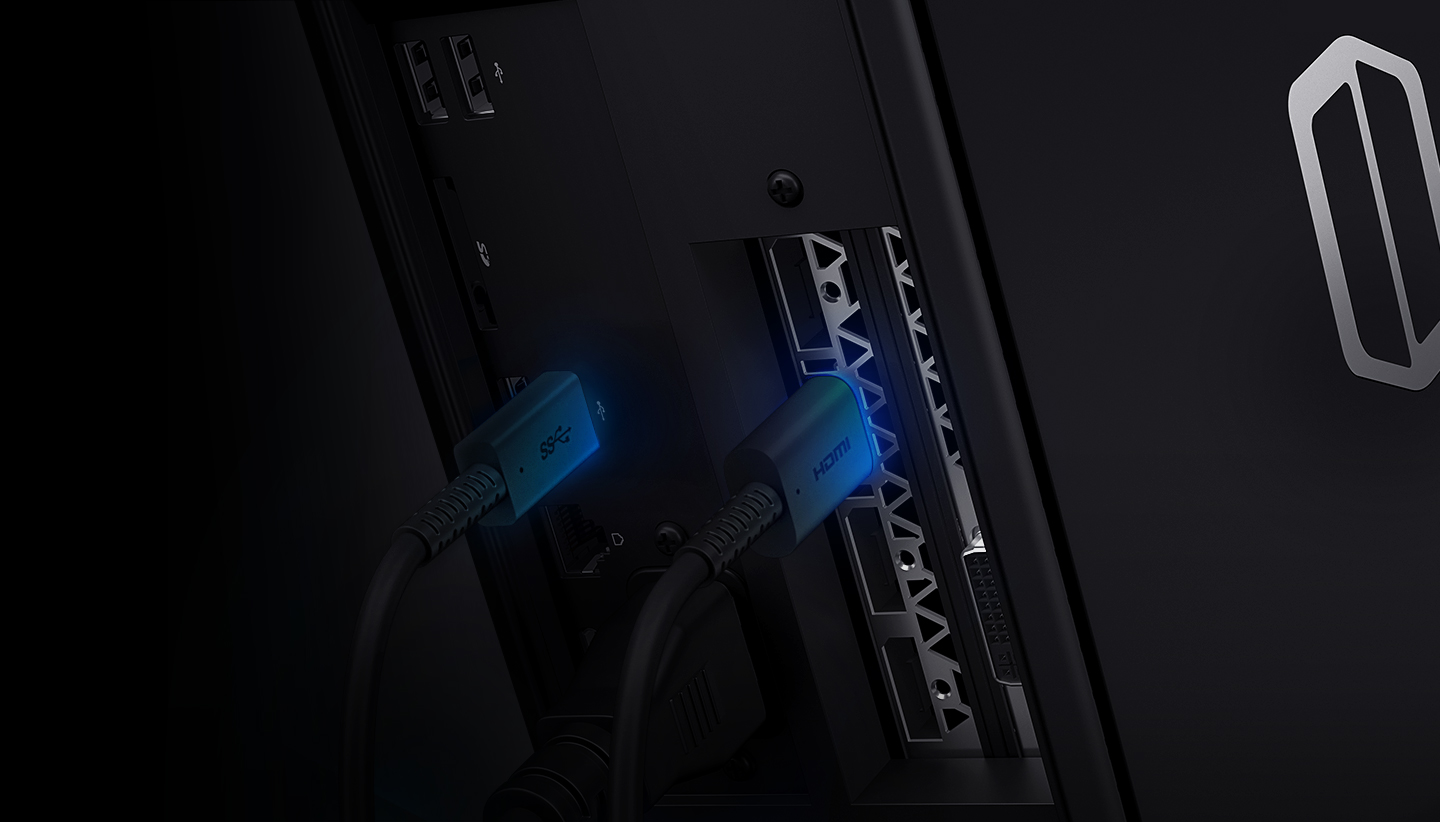 An image showing HDMI and USB 3.0 cables connected to ports on the back of a Samsung Desktop Odyssey device, both emitting blue lighting.