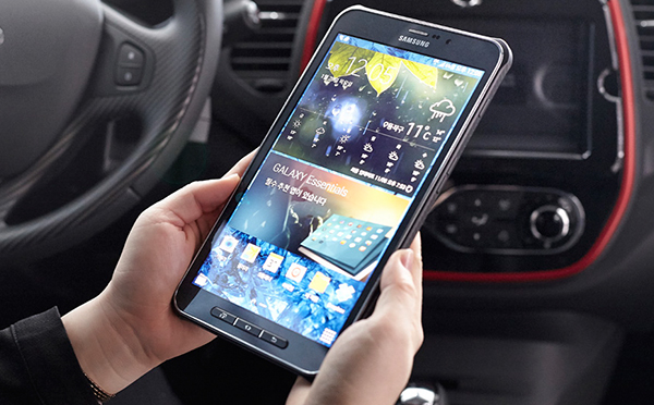 An image showing a man using a tablet in a car