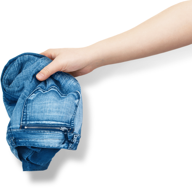 An image showing a user putting a pair of jeans into a QuickDrive device. 